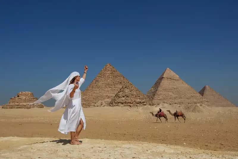 una donna davanti le piramidi , vacanza egitto piramidi e mare