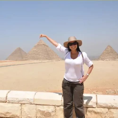 una donna scatta foto con le piramidi , citta dell' Egitto