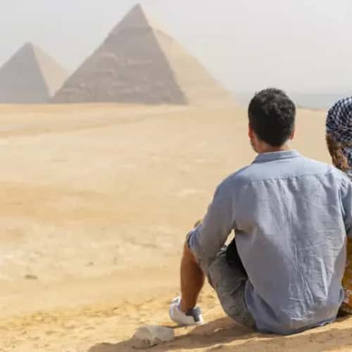 una coppia davanti le piramidi, andare in egitto
